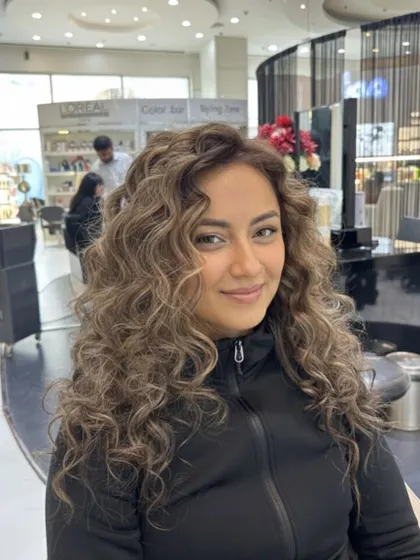Another angle of this elegant curly hair transformation. The color looks soft and blended, and the curls are perfectly formed and frizz-free.