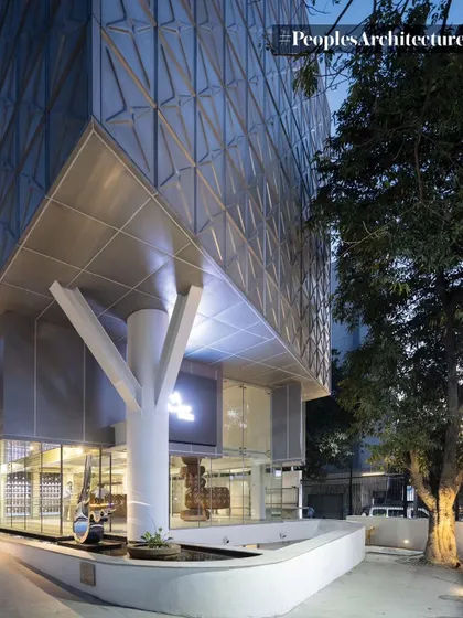 The corner view of MAP at dusk, where the illuminated interior and the structural 'tree' column become prominent features.
