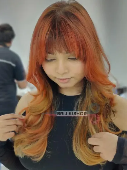 A closer look at this Y2K-inspired orange and blonde color. The layers and bangs add to the retro, funky vibe.