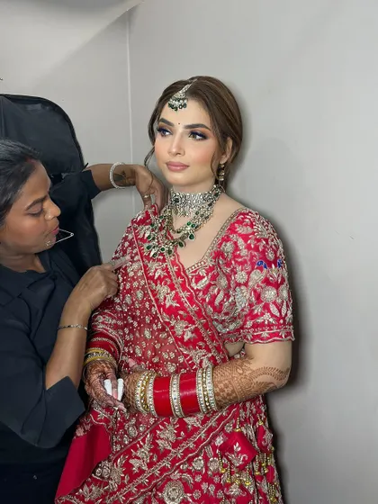 A behind-the-scenes shot of the final touches. Every detail, from the makeup to the dupatta setting, is meticulously handled by my team.