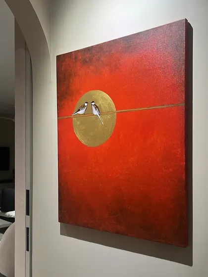 This vibrant painting of two birds on a wire was installed in a client's home. The bold red background and gold leaf moon make it a striking piece of wall art.