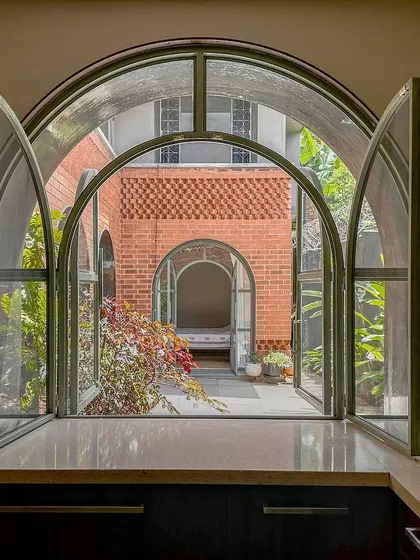 The view from the kitchen window looks out across a courtyard to another part of the house. This pass-through window connects the kitchen to the outdoors and allows for easy serving to the patio.