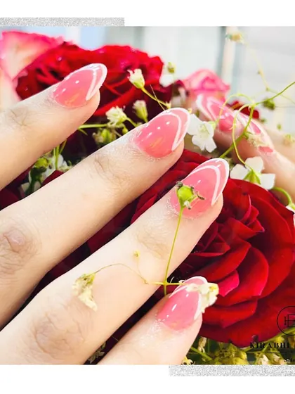 The elegant pink and white abstract French nails photographed with a beautiful bouquet of roses, showing how your nails can complement any aesthetic.
