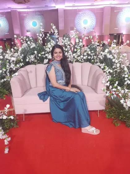 Taking a quiet moment before the start of a Sangeet. The beautiful floral decor and stage setup create a blissful and romantic atmosphere, setting the perfect scene for an evening of celebration that I am about to host.