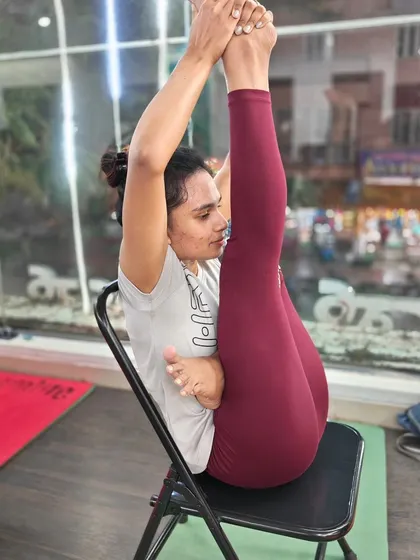 This seated leg-lift pose on a chair builds core strength and hamstring flexibility.