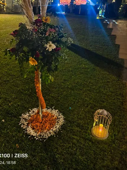Another decorative floral stand with a birdcage lantern at its base, adding to the ambiance of the Diwali party.