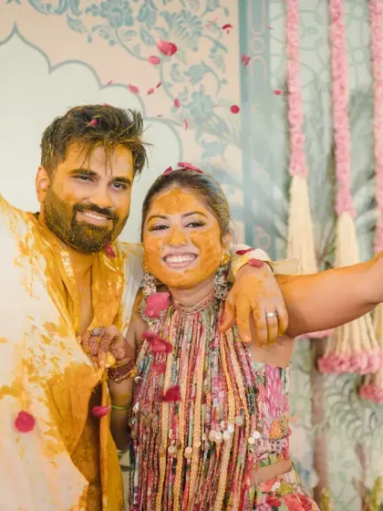 The couple, covered in haldi and petals, share a triumphant and happy hug. This photo perfectly encapsulates the joyful and messy conclusion of their ceremony.