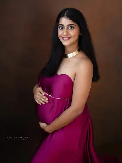 A beautiful portrait of a mother-to-be, looking confident and happy in a flowing magenta gown. A perfect way to remember the strength and beauty of pregnancy.