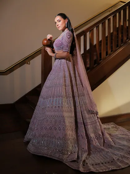The long trail of this lavender lehenga adds a touch of modern royalty, perfect for a grand entrance.