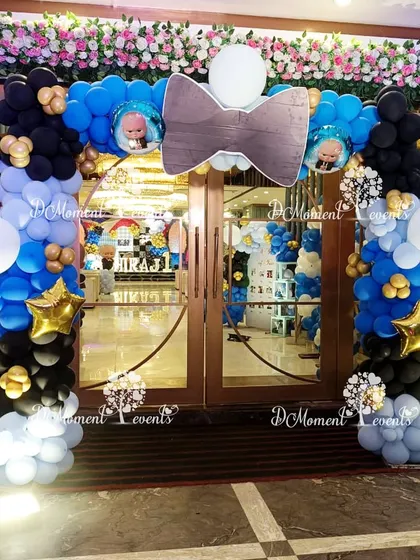 A closer look at the "Boss Baby" entrance arch, featuring a large bowtie prop and floral arrangements for an extra touch of class.