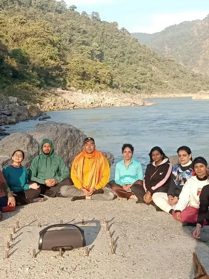 A group meditation session by the river, finding collective calm and connecting with the spiritual energy of Rishikesh.