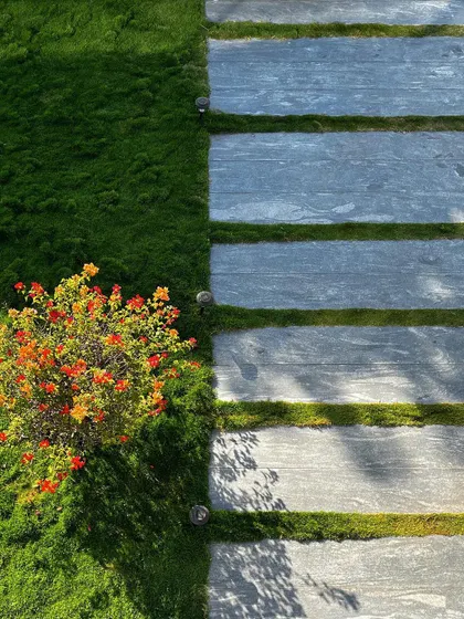 Detail is everything. This pathway combines clean stone pavers with soft mondo grass, creating a textural contrast underfoot. The composition of hardscape and softscape is fundamental to how I approach every garden design.