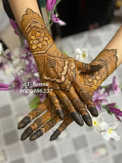 A striking design featuring a large floral motif in the center, with detailed patterns on the fingers and a cuff at the wrist.