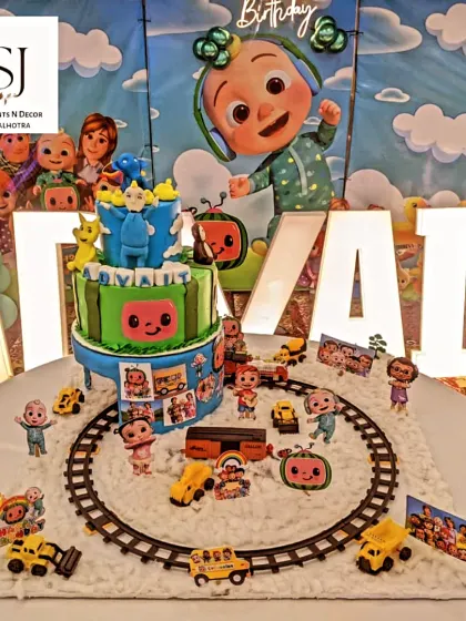 A close-up of the incredible Cocomelon-themed cake, complete with a toy train track and all the main characters.
