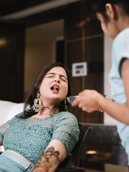 When you're the bride at the mehendi, you get taken care of. Here, Disha is being fed by her cousin, a funny and real moment that happens when your hands are covered in henna.