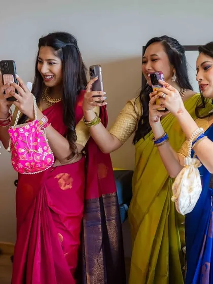The modern-day bride tribe. The bridesmaids all take photos of their friend on their phones, a fun and relatable candid moment.
