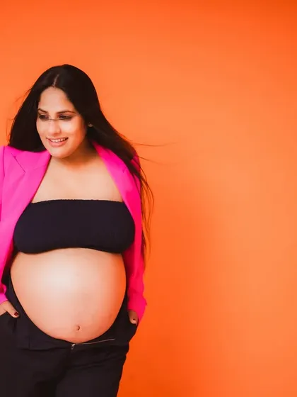 A confident and happy portrait from a modern maternity session. The wind in her hair adds a touch of dynamic energy to this stylish shot.