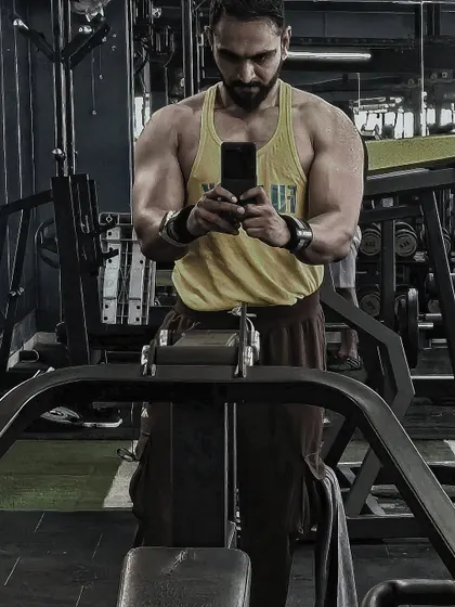 Even on a Sunday, the work doesn't stop. A dedicated client takes a moment to check his progress in the mirror, a key tool for monitoring form and muscle development.
