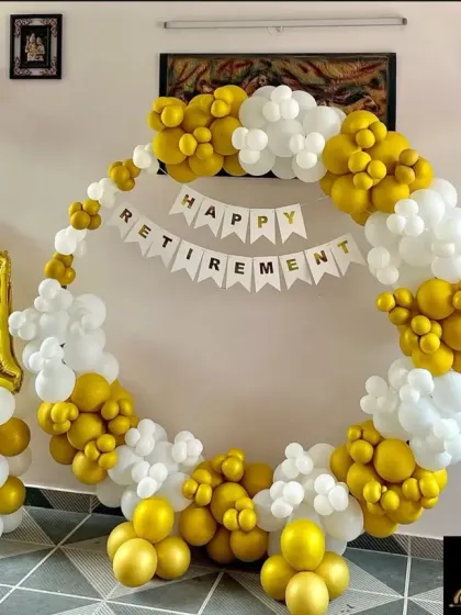 I help companies celebrate important milestones like retirements. This setup features a full circular balloon frame in white and gold, a "Happy Retirement" banner, and large foil number balloons to mark the years of service.