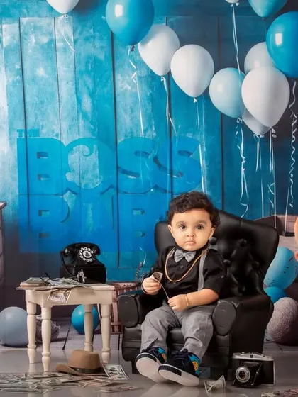 The 'Boss Baby' theme is a popular choice for first birthdays. This photo shows the full setup, complete with a tiny leather chair, prop money, and character cutouts, creating a fun and memorable scene.