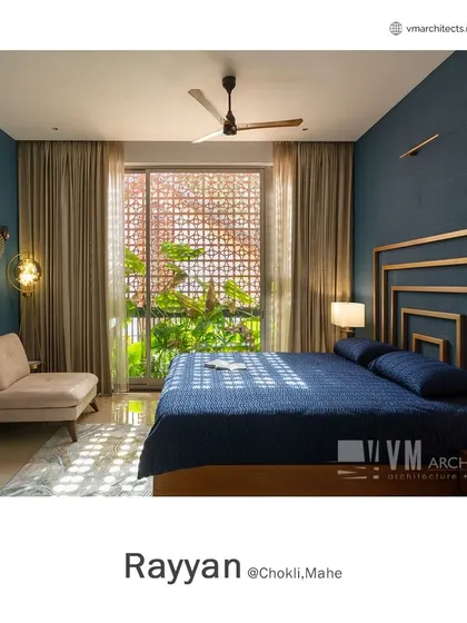 This bedroom in Rayyan features a deep blue accent wall and a geometric gold-finish headboard. The patterned jali window filters natural light, creating beautiful shadow play.