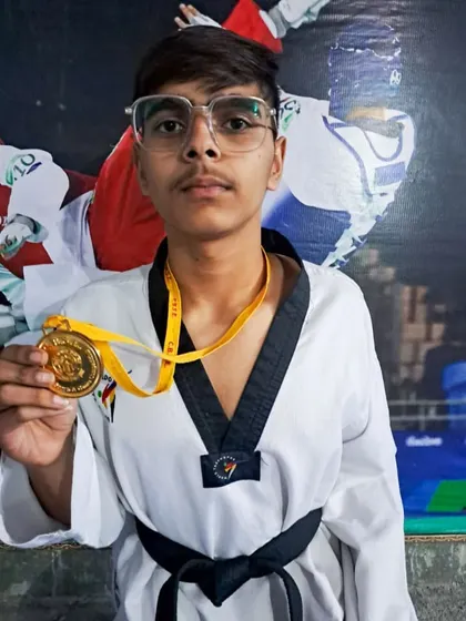 A student with his CBSE Gold medal, marking his selection for the CBSE Nationals.