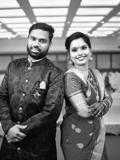 A classic black and white portrait of the engaged couple, showcasing their elegant traditional attire.