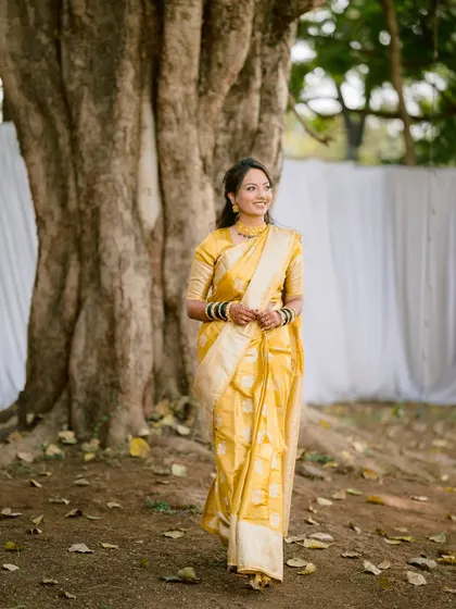 A full-length shot of the bride walking gracefully in her traditional yellow saree.