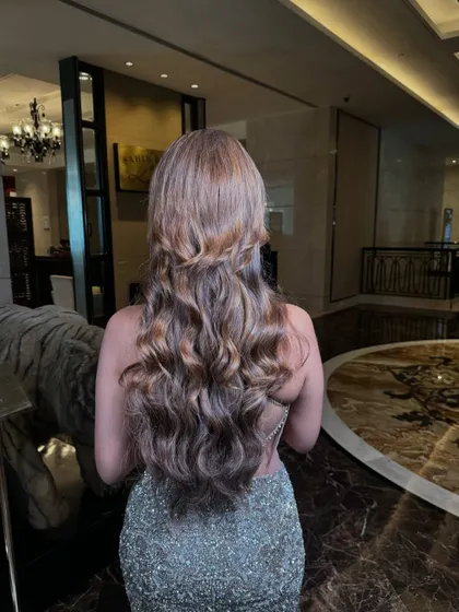 Voluminous, glamorous waves with a half-up twist. This hairstyle is perfect for a reception or cocktail party, designed to make you feel like a star.
