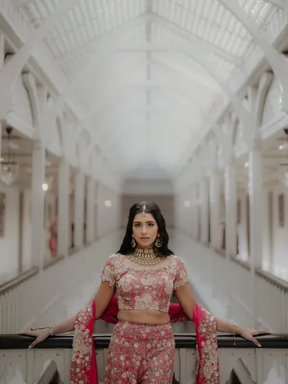 A stylish portrait of Nandini and Sahil at the Taj Mahal Palace, Mumbai. The grand, symmetrical hallway provides a stunning architectural backdrop for this elegant and poised couple shot.