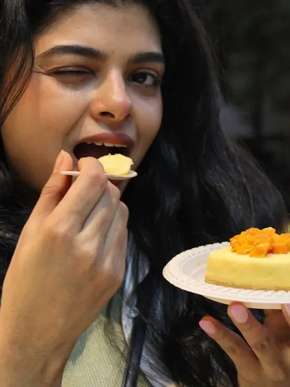 A happy customer enjoying a slice of our seasonal Mango Cheesecake. Nothing makes us happier than seeing the joy our desserts bring.