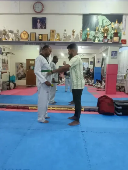 An adult student receives his green belt.