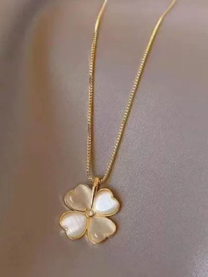 A clear, beautiful shot of the mother-of-pearl four-leaf clover necklace, showing the iridescent quality of the pendant.