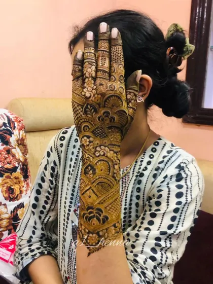 A full-arm bridal design shown against the client's face, demonstrating the scale and impact of the artwork.