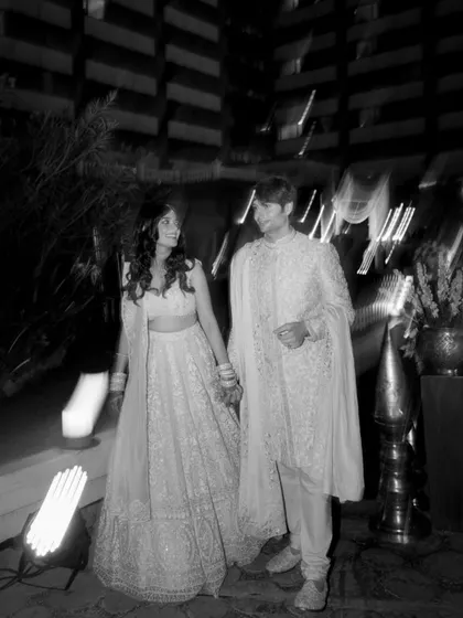 A candid, motion-blur shot of the couple walking at night, captured in timeless black and white.