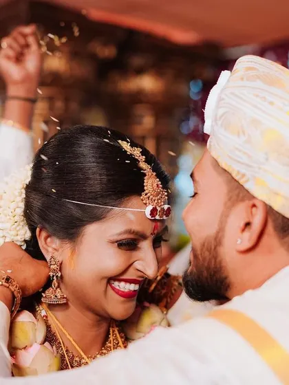 A close-up shot of the bride's radiant smile as the groom ties the Mangalsutra, a moment of pure happiness.