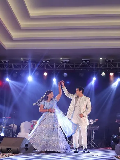 The couple takes center stage for a dance during their Dandiya night. I ensure the stage, lighting, and sound are perfectly set up to highlight these key performances and create a concert-like atmosphere.