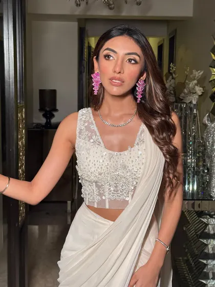 A confident and stylish pose. The soft, wavy hair and the glowing makeup create a look that is perfect for any celebration.