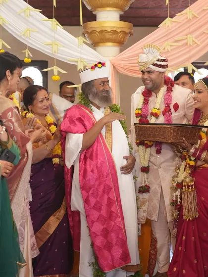 Gurudev Sri Sri Ravi Shankar personally blessing a newly married couple at the ashram. His presence adds a layer of profound grace and sanctity to the wedding, a unique aspect of getting married with us.