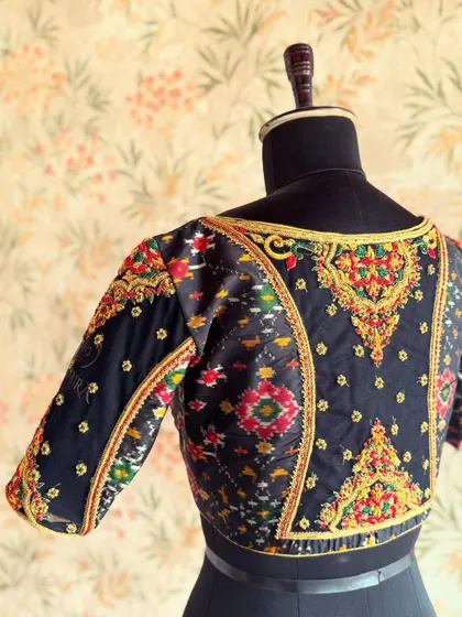 I love incorporating traditional textiles in modern ways. This blouse uses a black Ikat-style fabric, enhanced with colorful embroidery along the seams.