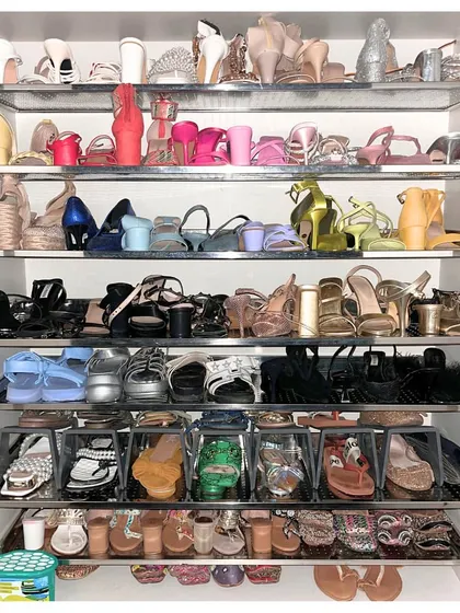 This shoe closet is a colorful masterpiece. We organized this extensive collection by color and style, using a mix of open shelves and clear drop-front boxes for flats to maximize visibility.