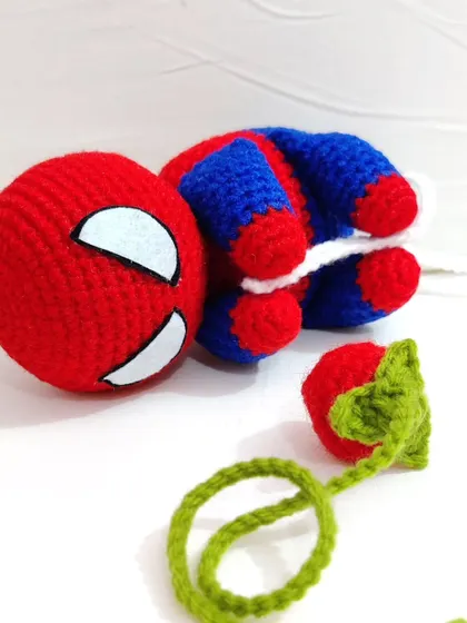 Spiderman taking a little break with a crochet strawberry.