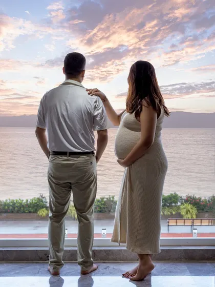 Sometimes the most beautiful backdrop is your own home. This cozy, at-home maternity session was shot against their window, using the natural sunset to create a warm, personal, and intimate portrait.