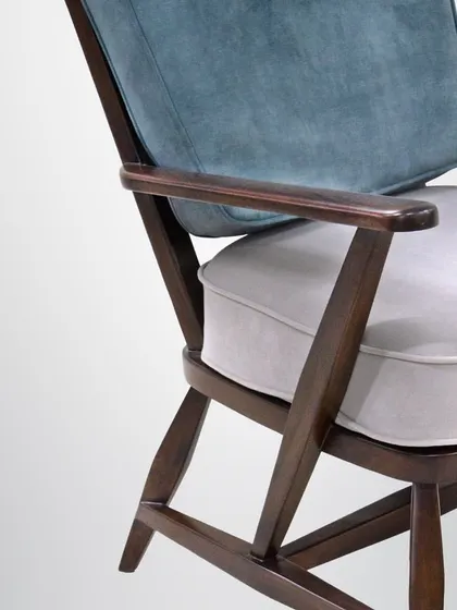 This rustic armchair is crafted from rich mahogany and features dual-tone cushions. Its classic, sturdy frame provides a sense of rustic radiance and comfort.