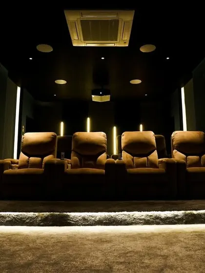 The clean, modern design of this Tenkasi theater features vertical wall panels with integrated lighting and a raised platform for the recliners, ensuring optimal viewing for everyone.
