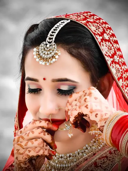 A beautiful portrait of the bride adjusting her nose ring, a candid moment that feels both traditional and personal.