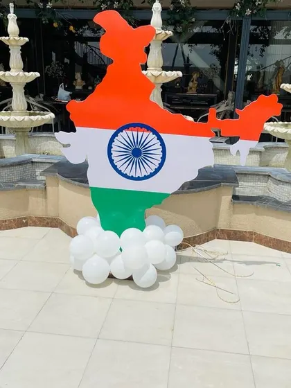 A large cutout of the map of India, colored like the flag, stands on a base of white balloons. This prop is perfect as a standalone decoration or as part of a larger photo booth setup.