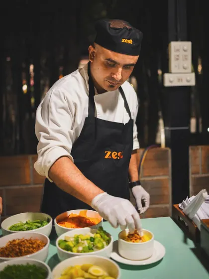 Our chef at the Khow Suey station, surrounded by bowls of fresh and flavourful accompaniments.