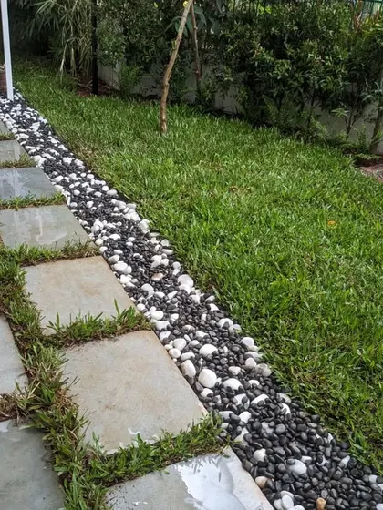 The clean lines of the stone path and pebble border contrast nicely with the organic feel of the lawn.