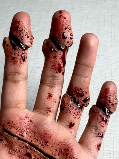 A close-up of the SFX makeup, showing the texture and detail of the fake wounds and blood.